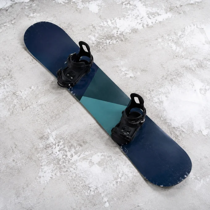 A navy and teal snowboard with bindings